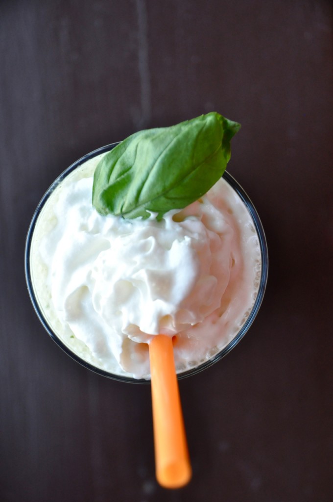Top down shot of a Peanut Butter and Basil Milkshake topped with whipped cream