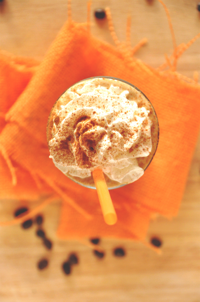 Top down shot of a glass of Pumpkin Frappuccino topped with whipped cream and cinnamon
