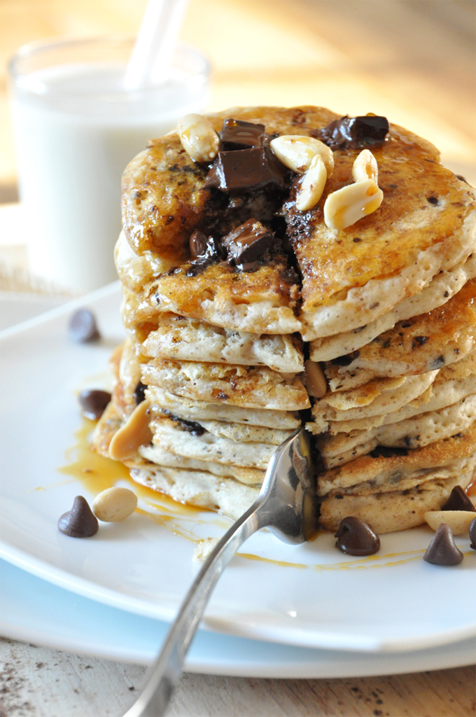 Using a fork to cut a big bite out of a stack of Vegan Snickers Pancakes