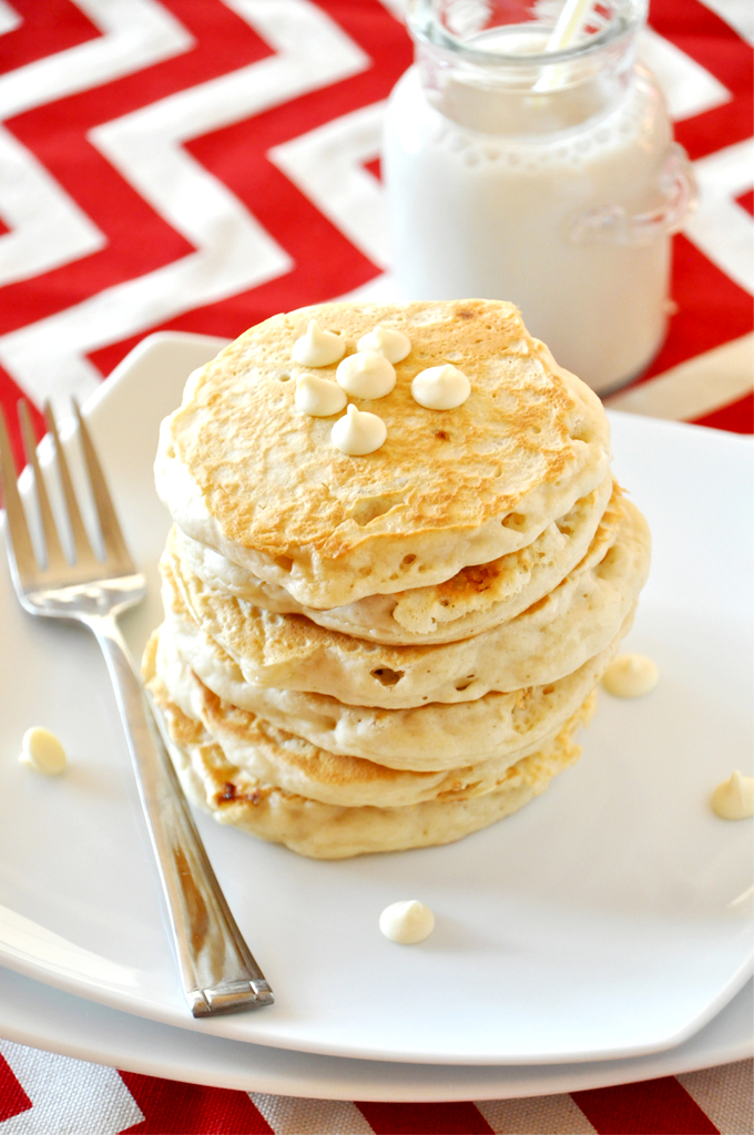 white chocolate macadamia nut cookie pancakes! Tall stack of White Chocolate Macadamia Nut Pancakes with a jar of soy milk