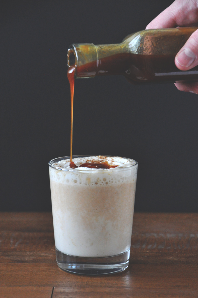 Drizzling homemade caramel sauce onto a Boozy Pumpkin White Hot Chocolate