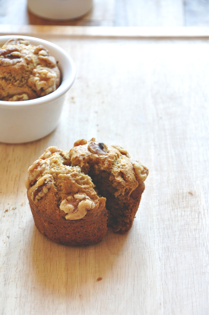 Sliced open Vegan Banana Nut Muffin with the other muffin in the batch behind it