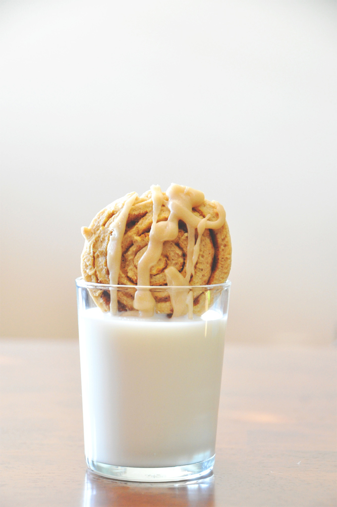Pumpkin Cinnamon Roll Cookie dipped into a glass of milk