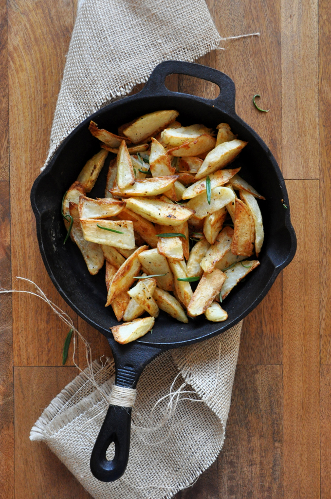 Cast-iron skillet of homemade Crispy Baked Rosemary Garlic Fries 