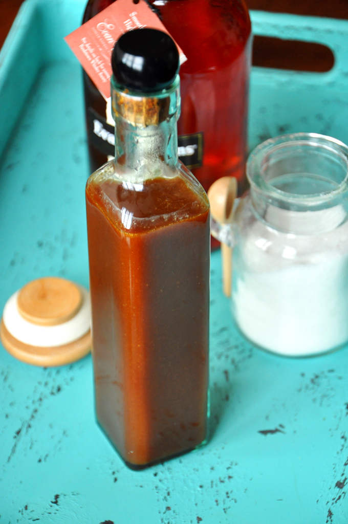 Bourbon Caramel Sauce || Minimalist Baker Bright blue tray with bourbon, sugar, and a bottle of homemade Bourbon Caramel Sauce