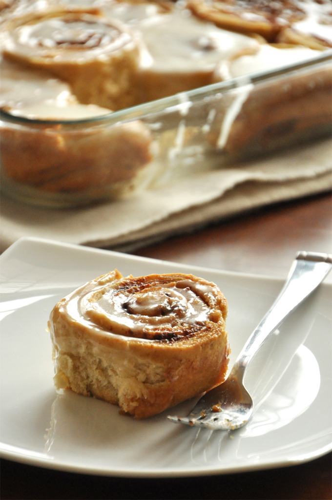 Delicious Overnight Honey Wheat Cinnamon Rolls on a plate and in a baking pan