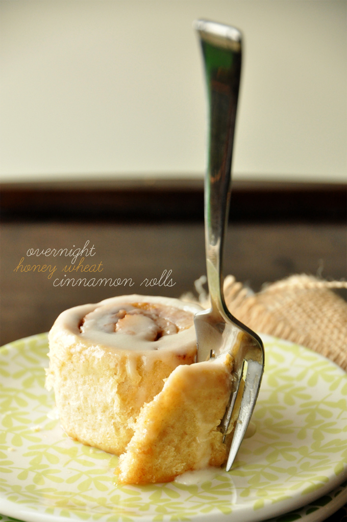 Using a fork to grab a bite of one of our Overnight Honey Wheat Cinnamon Rolls