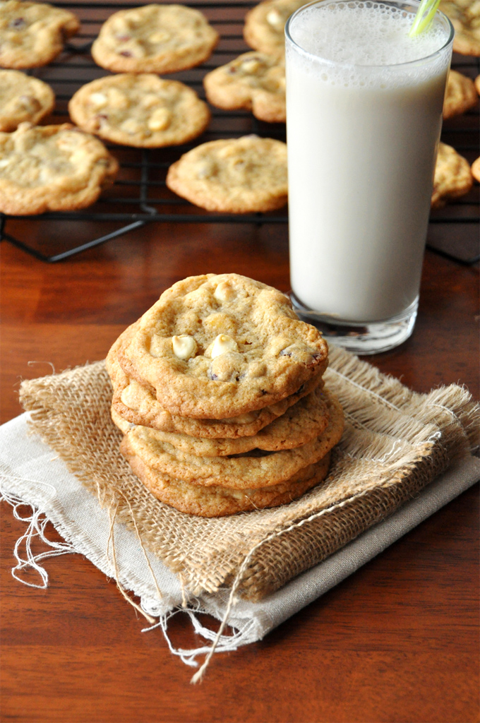 White Chocolate Cranberry Cookies! Glass of milk alongside a batch of our White Chocolate Cranberry Cookies recipe