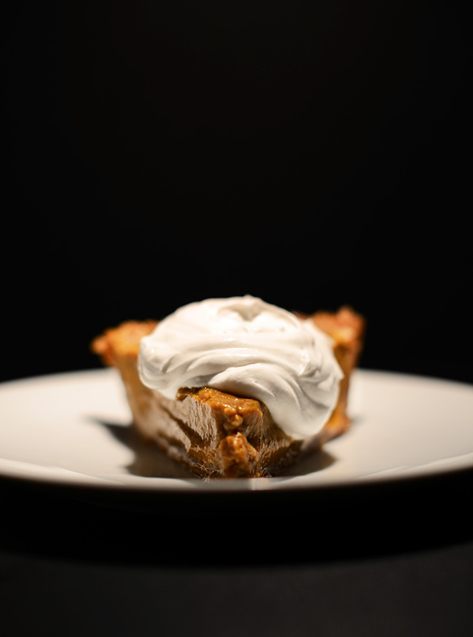 Plate with a slice of No-Bake Pumpkin Pie topped with a big dollop of coconut whipped cream