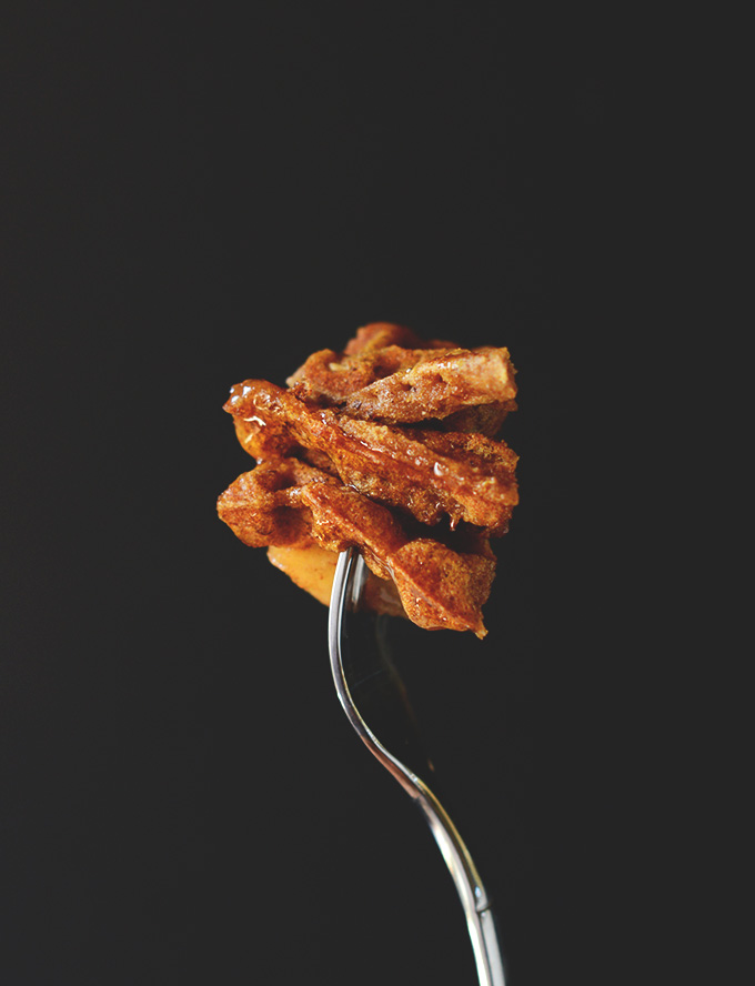 Holding up a fork with a big bite of Vegan Cinnamon Apple Waffles