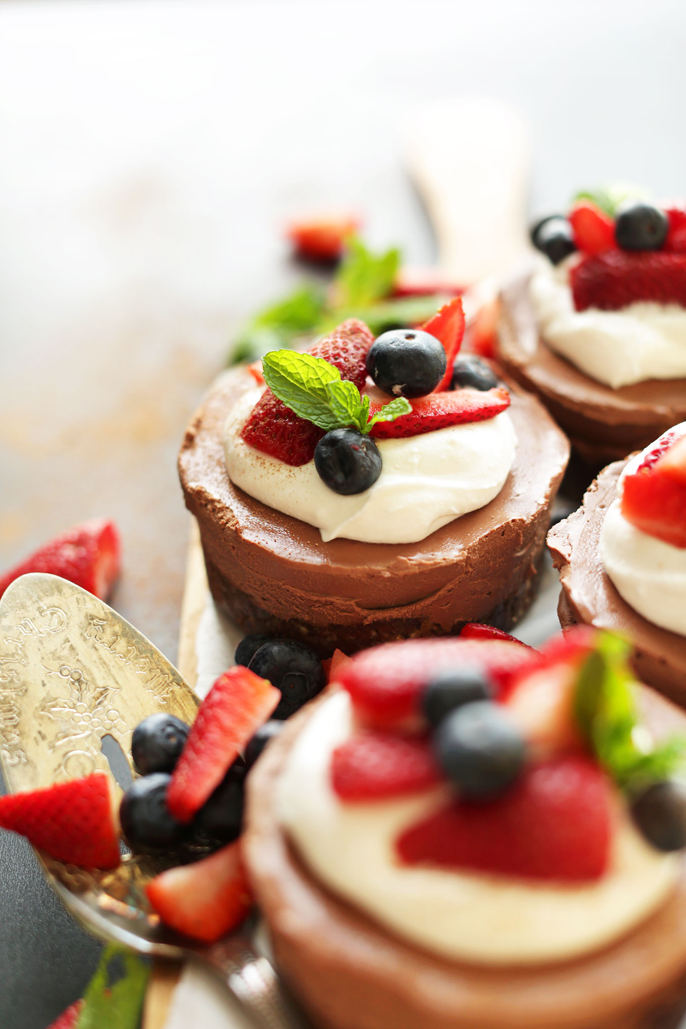 Mini Vegan Chocolate Cheesecakes with coconut whip and fresh berries