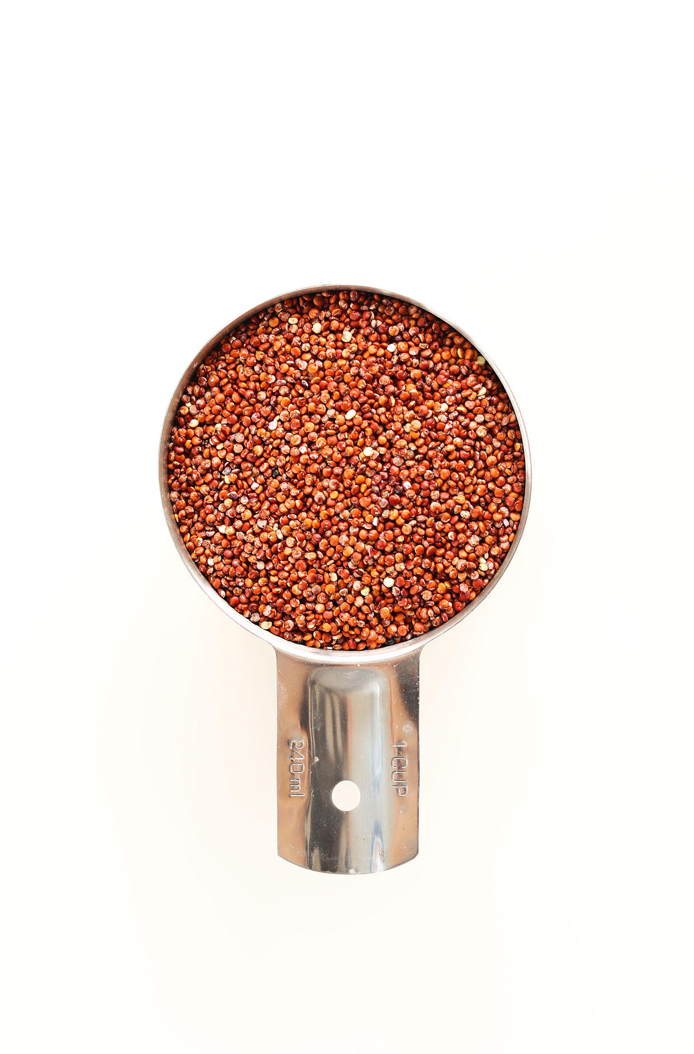 Measuring cup filled with quinoa ready to be cooked for gluten-free vegan Quinoa Spring Rolls