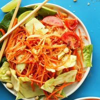 Chopsticks resting on a plate of our Thai Papaya Salad recipe