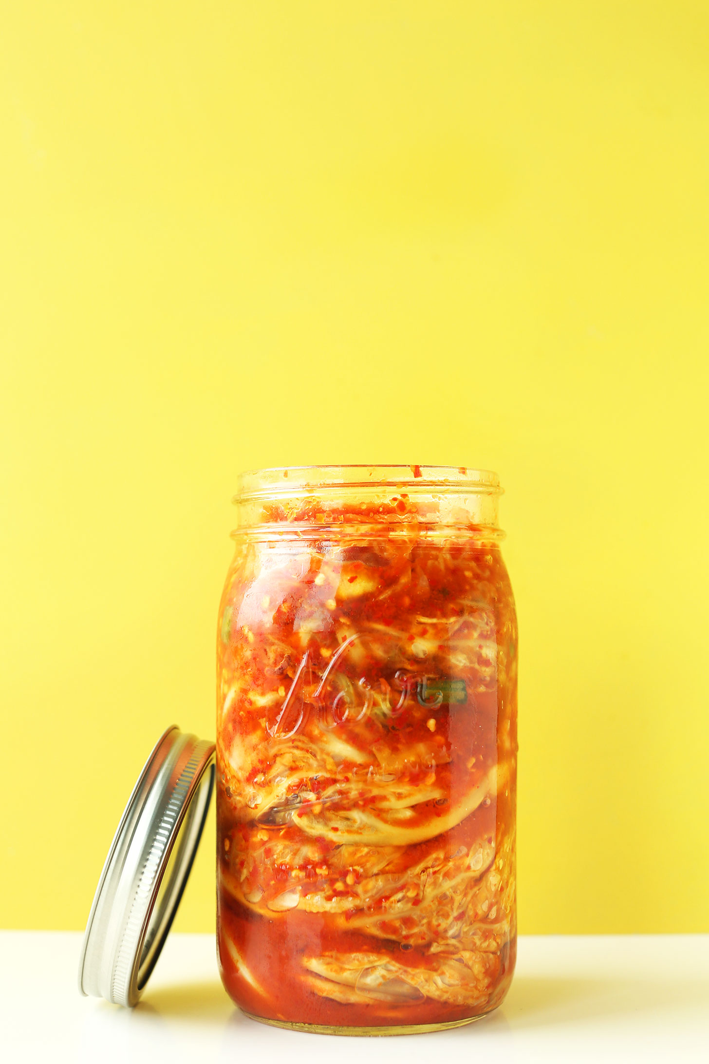 Jar of our easy kimchi recipe with the lid resting on the side