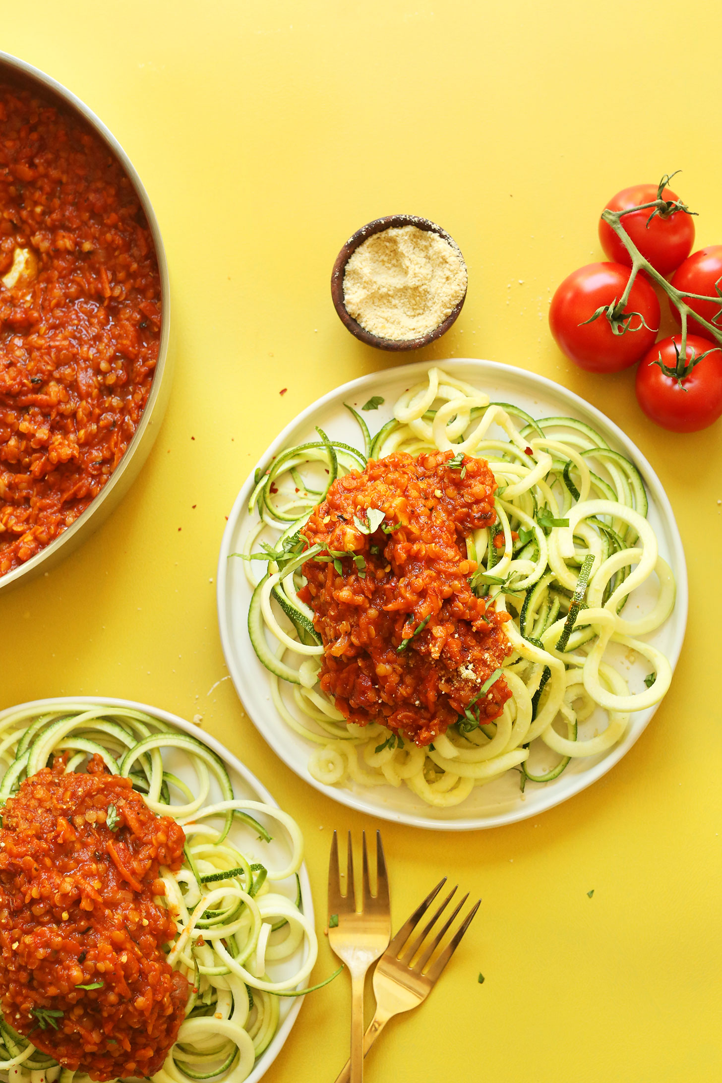 Dinner plates filled with a healthy meal of Spiralized Zucchini Pasta with Vegan Lentil Red Sauce