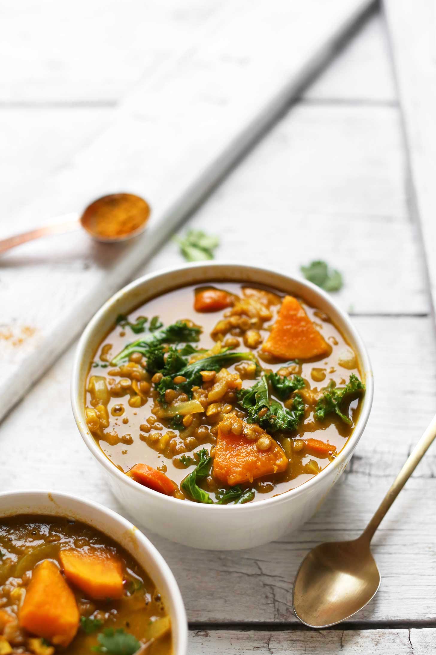 A hearty bowl full of gluten-free vegan Curry Soup with lentils and veggies 