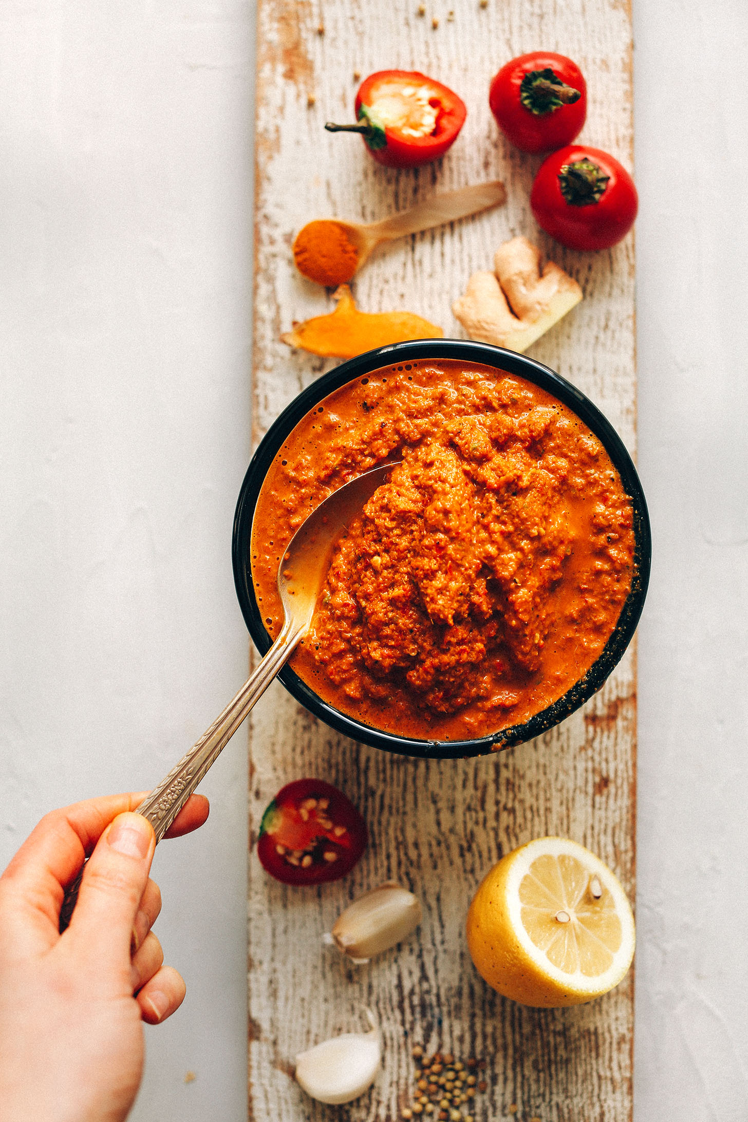 Wood plank with a bowl of Easy DIY Red Curry Paste