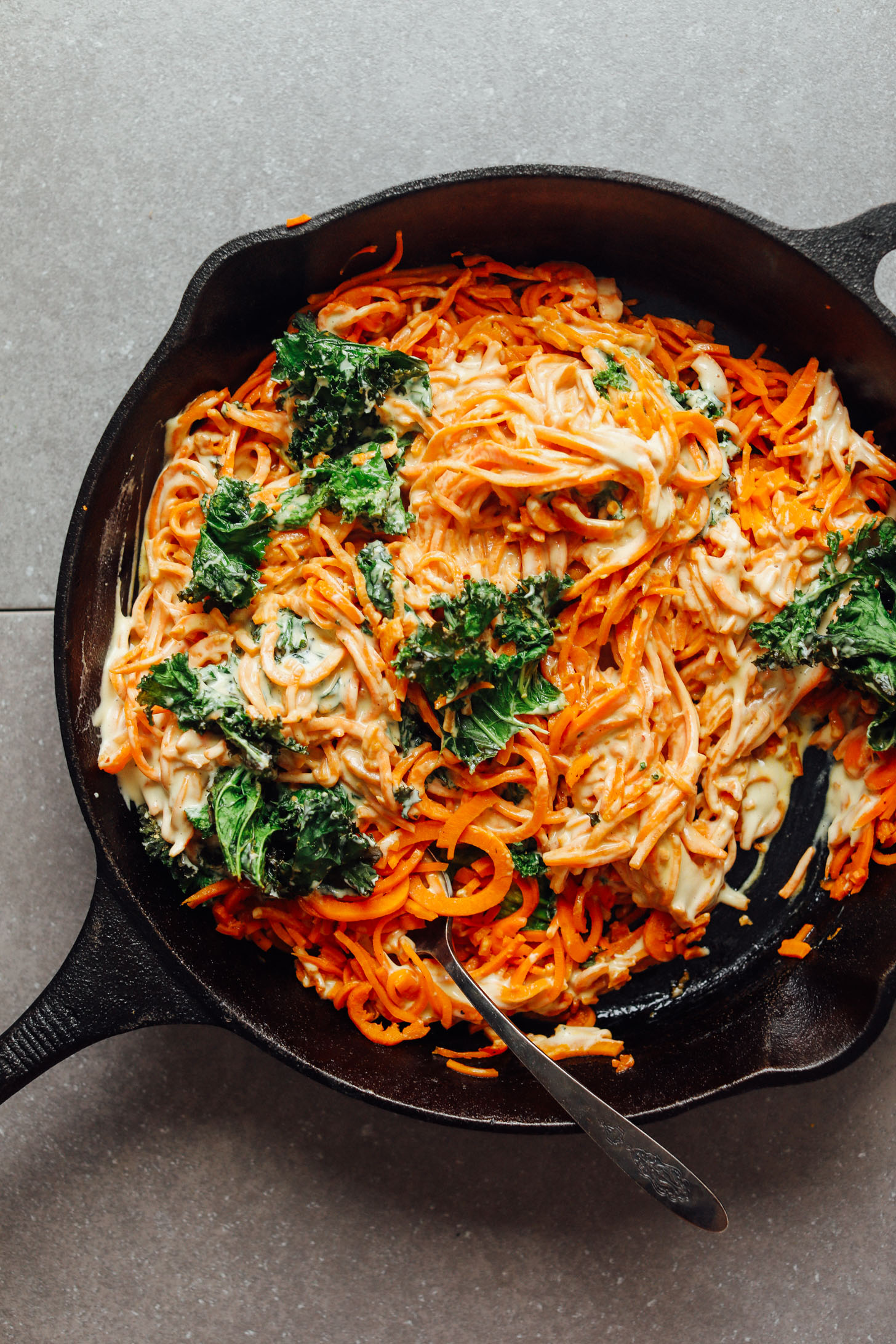 Cast iron skillet filled with vegan Garlicky Sweet Potato Pasta with Crispy Kale