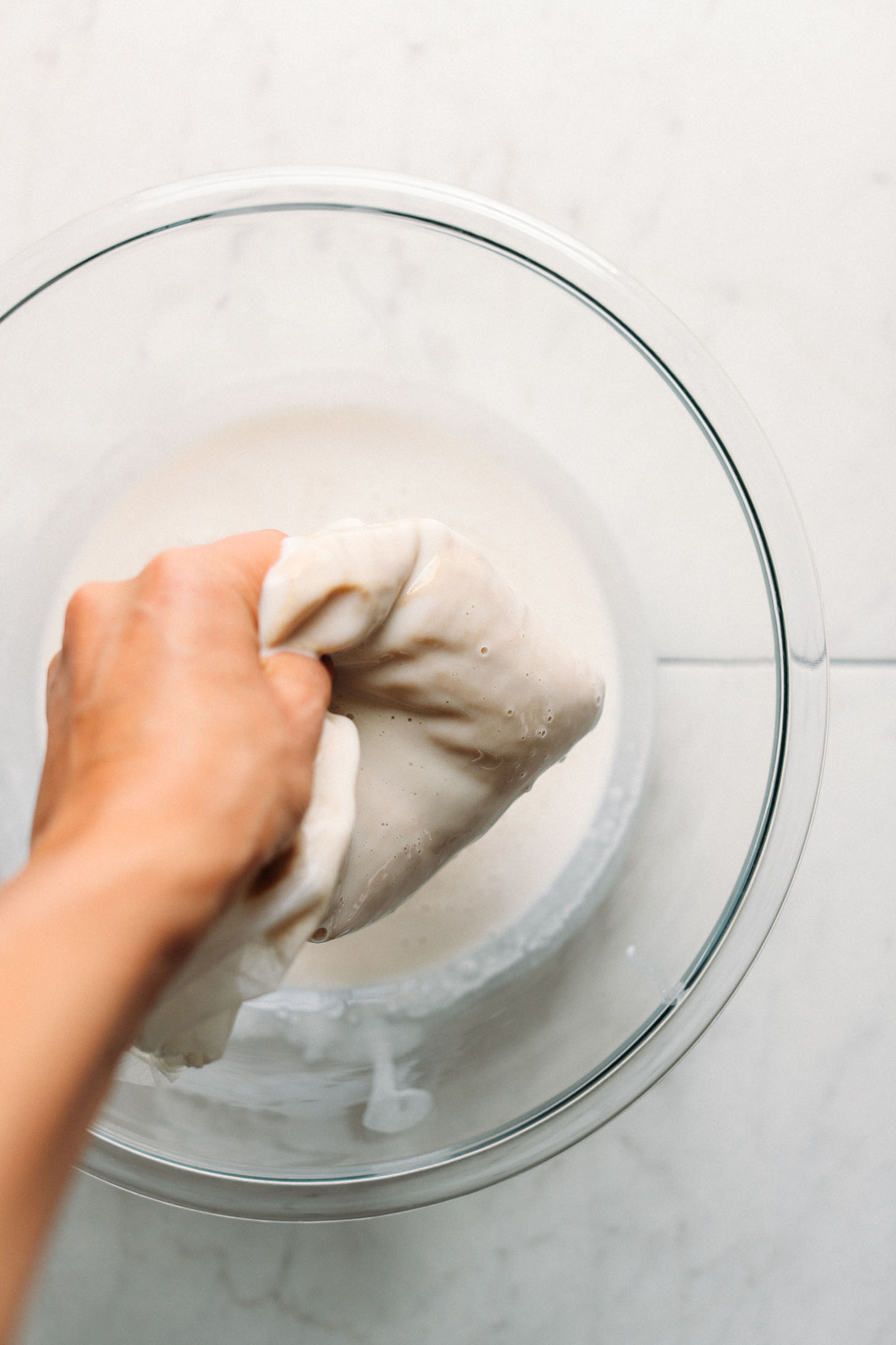 Straining homemade rice milk through a nut milk bag