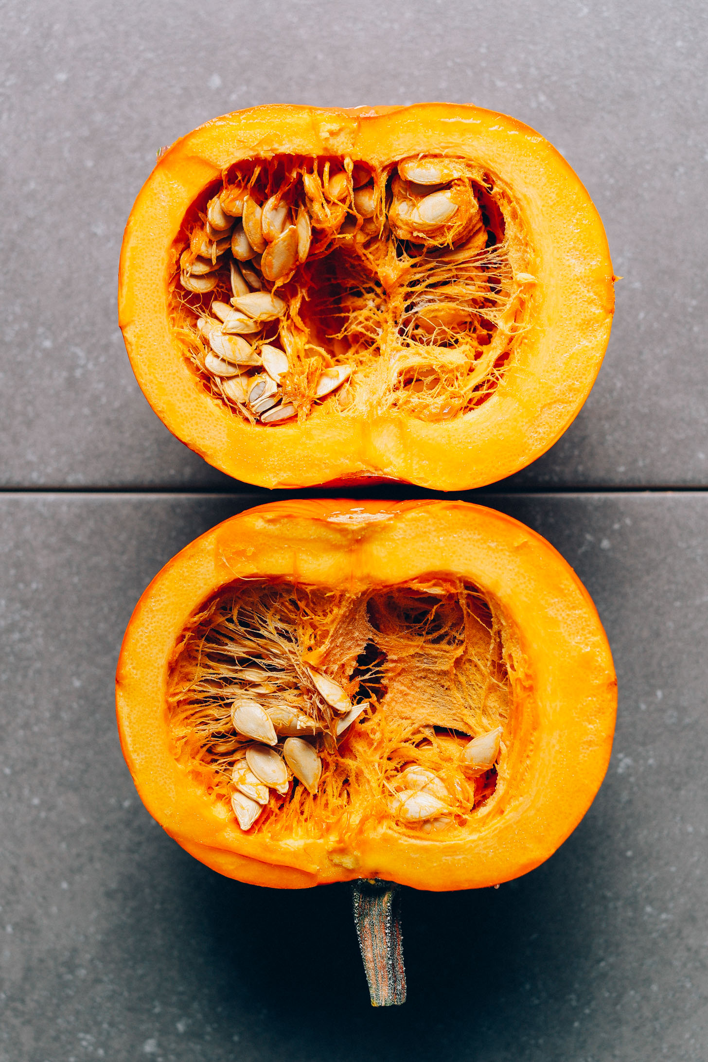 Pumpkin cut in half to show the seeds and rich orange color of the flesh