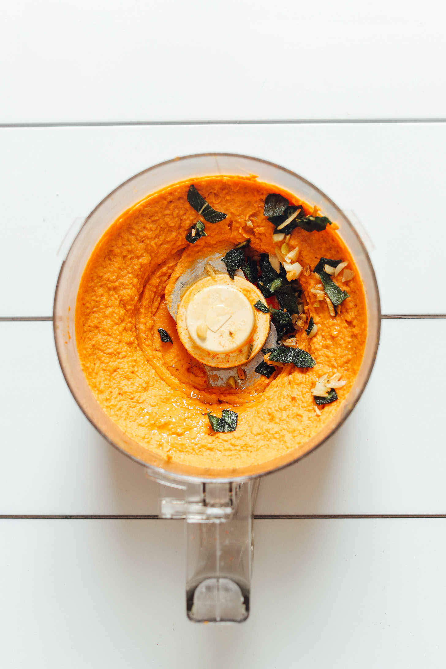 Food processor with freshly made White Bean Pumpkin Hummus with Crispy Sage