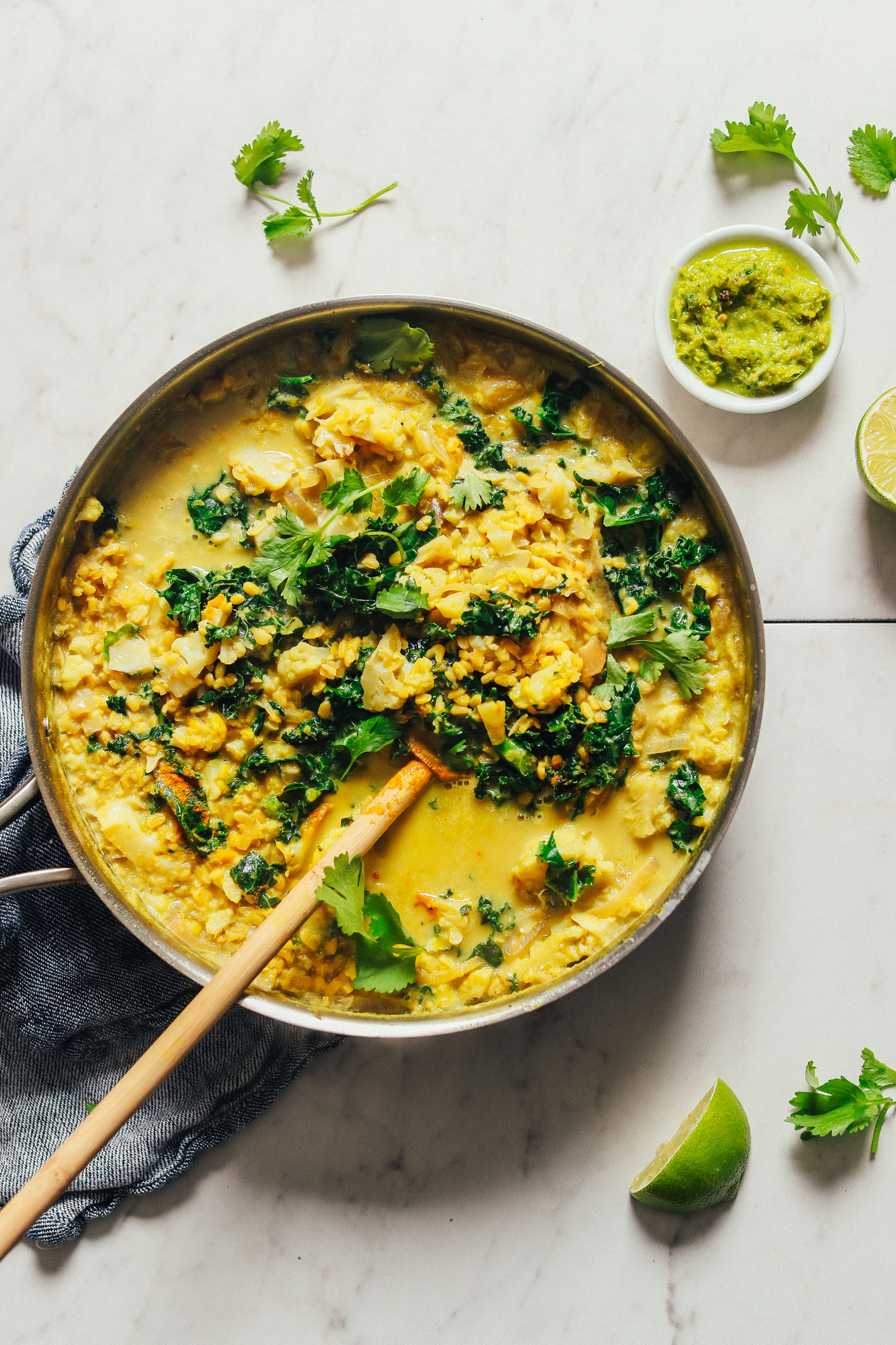 Overhead image of a pot of green curry with golden lentils