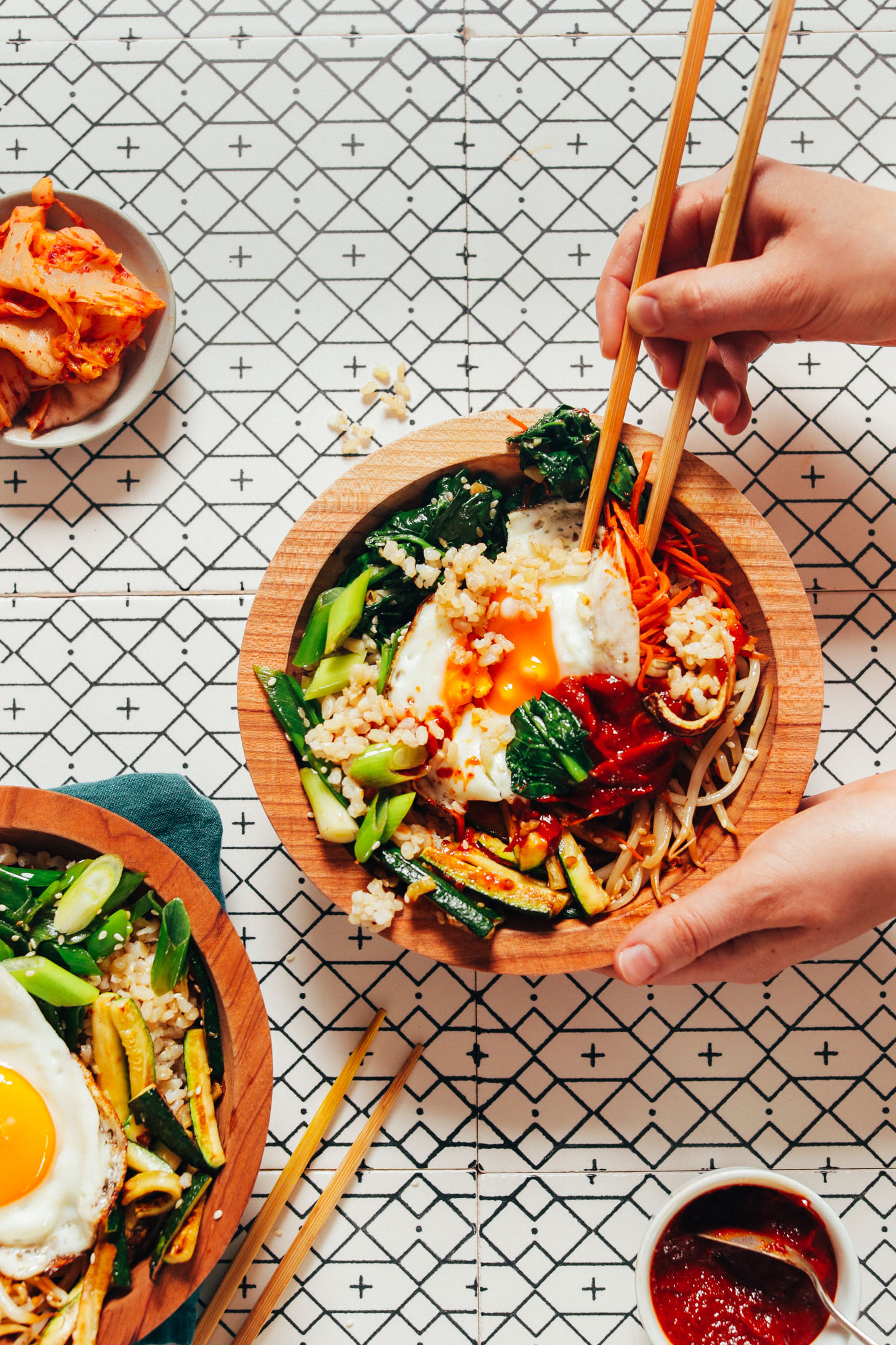 Using chopsticks to pick up a bite from a bowl of homemade Korean Bibimbap