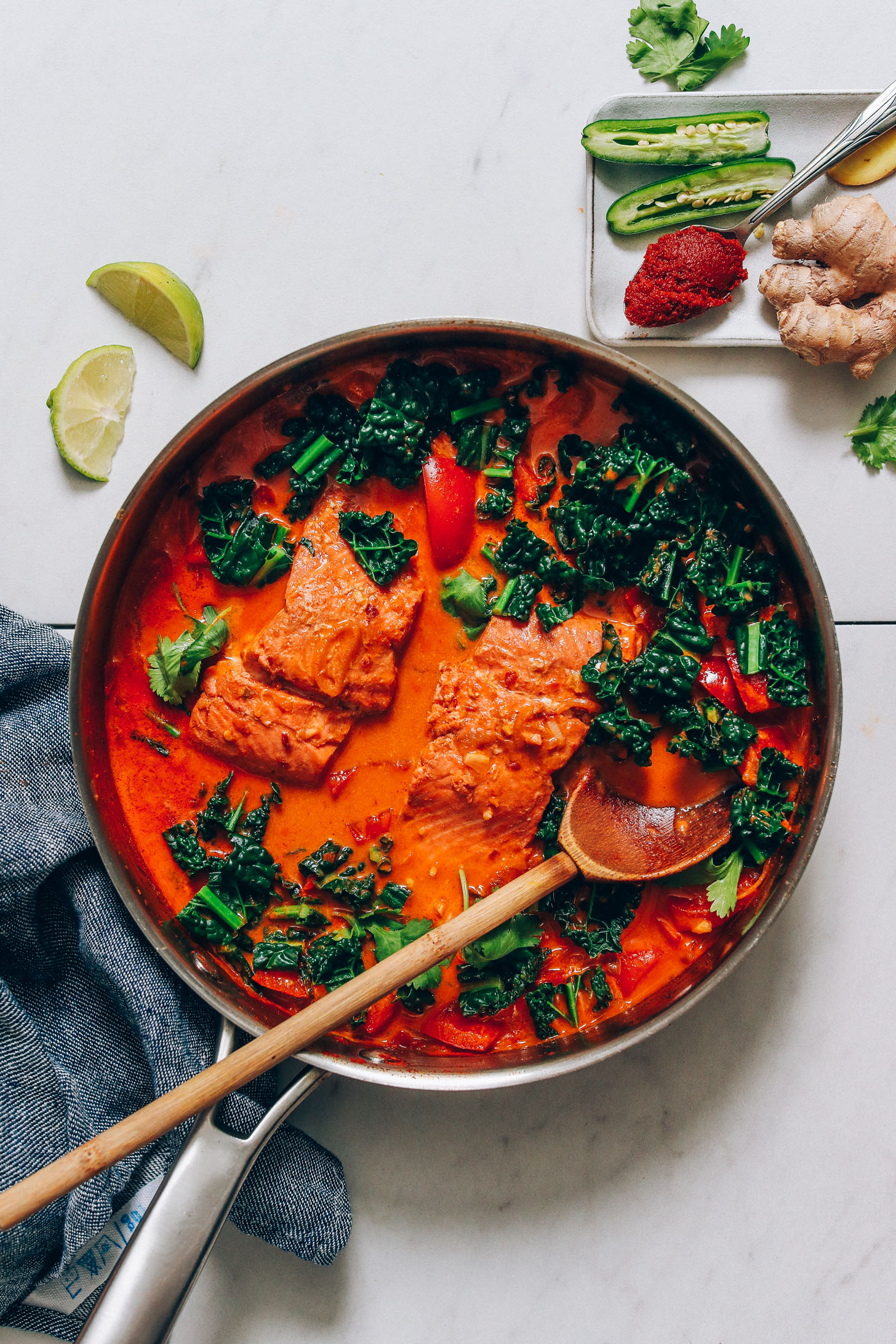 Wooden spoon resting in a pan of our 1-Pan Salmon Red Curry recipe
