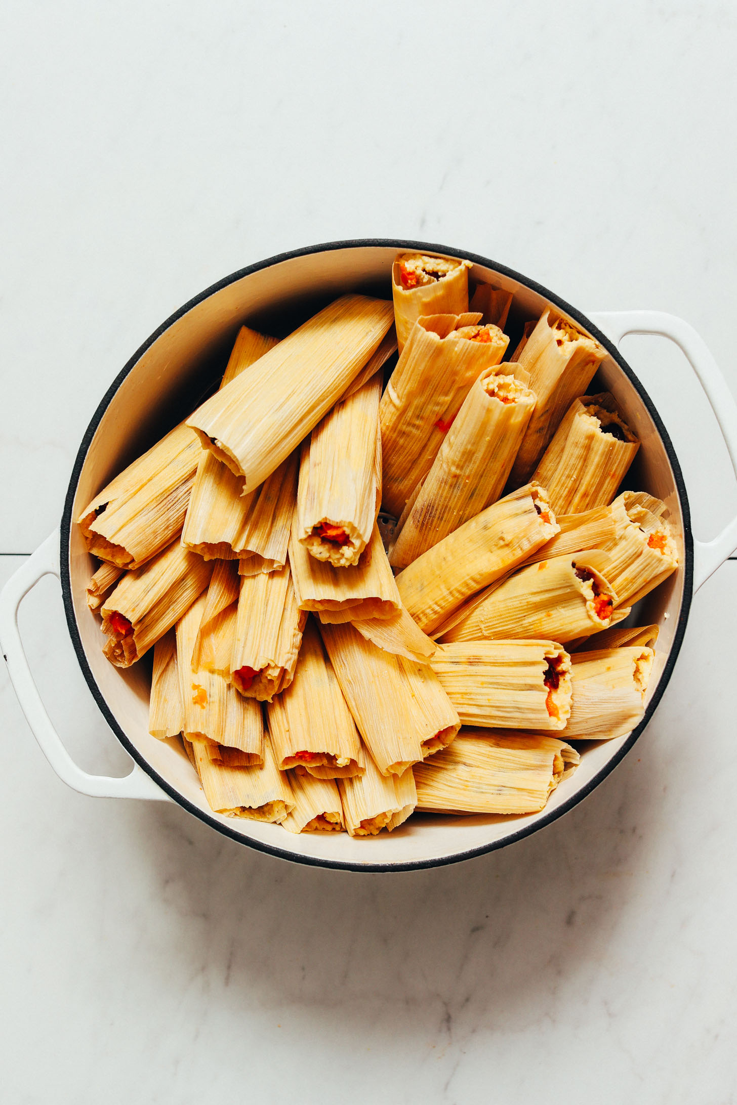 Large white pot filled with sweet potato black bean tamales