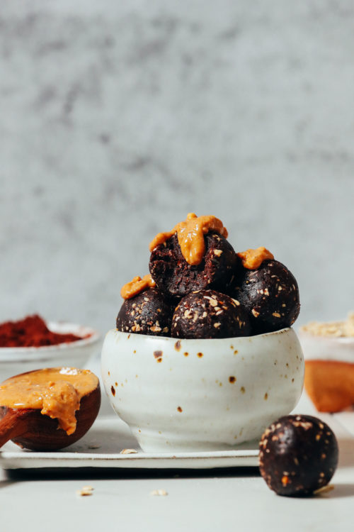 Bowl of No Bake Cookie Energy Bites topped with peanut butter