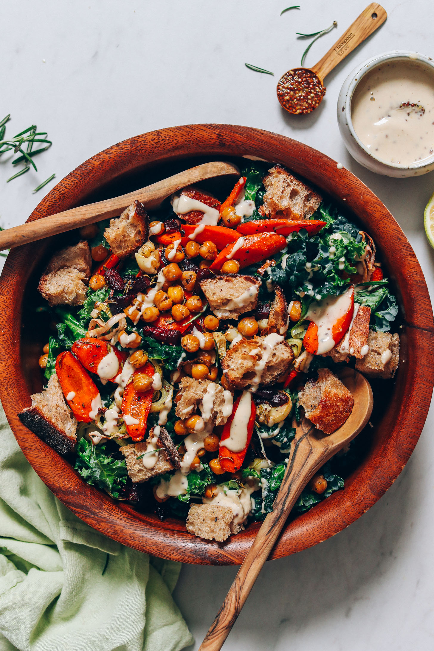 Large bowl of vegan panzanella next to a bowl of creamy mustard tahini dressing