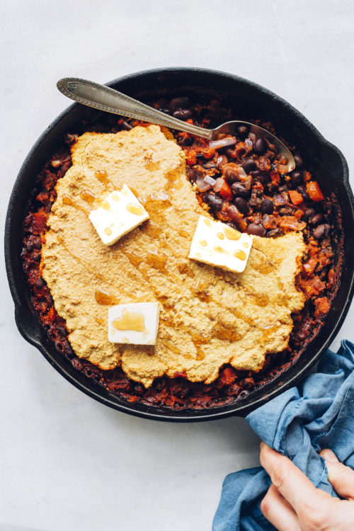 Cast iron skillet filled with Cornbread & Black Bean Enchilada Bake