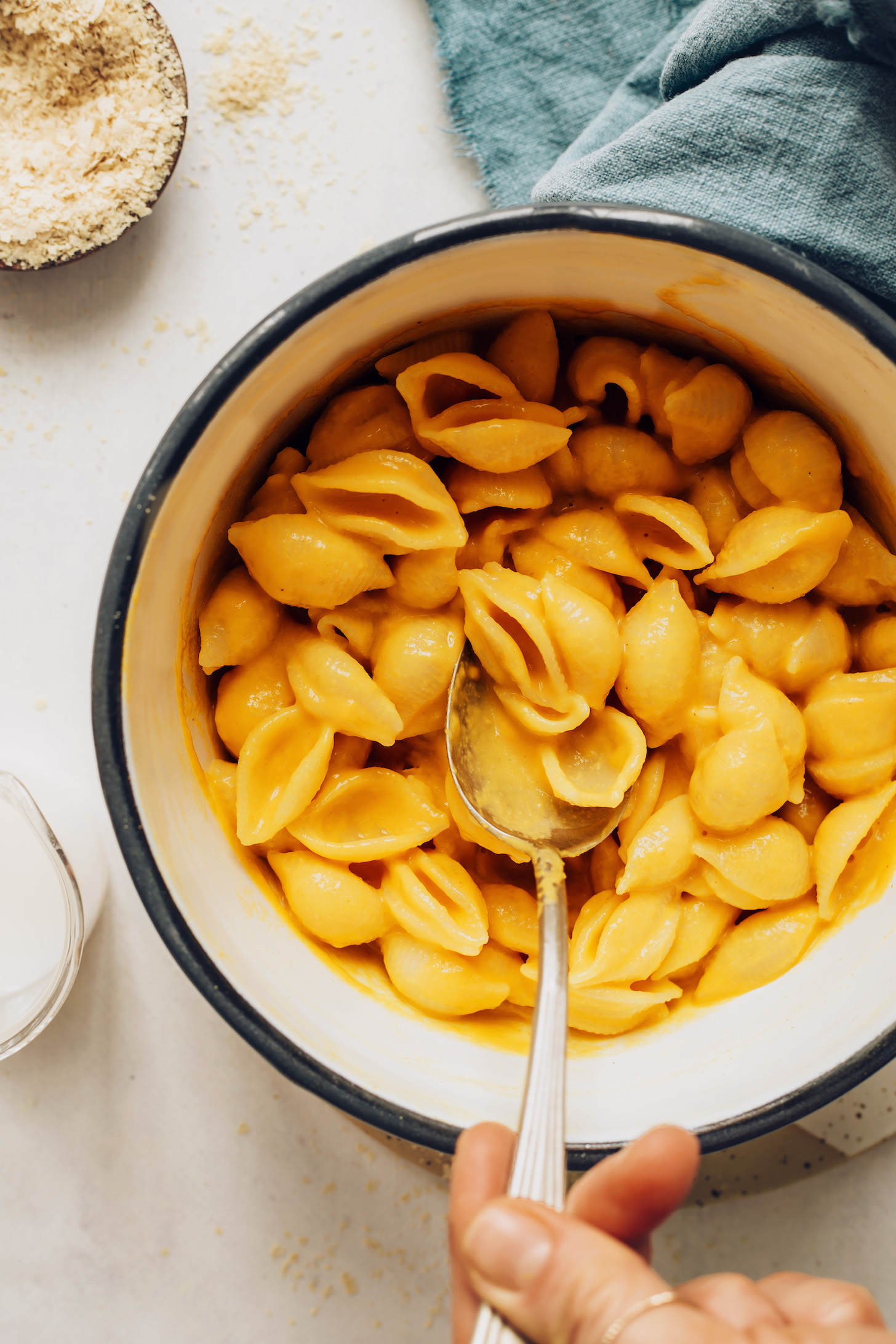 Using a spoon to stir a pot of vegan mac and cheese