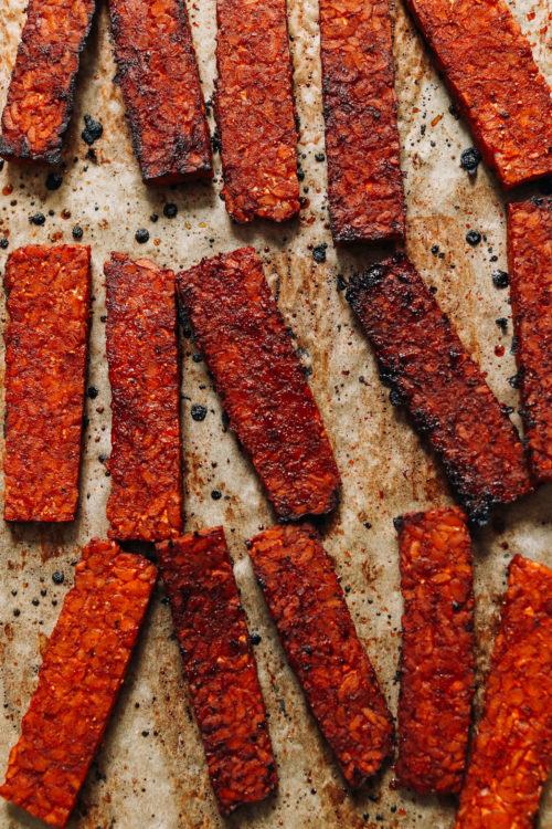 Strips of vegan tempeh bacon on a baking sheet
