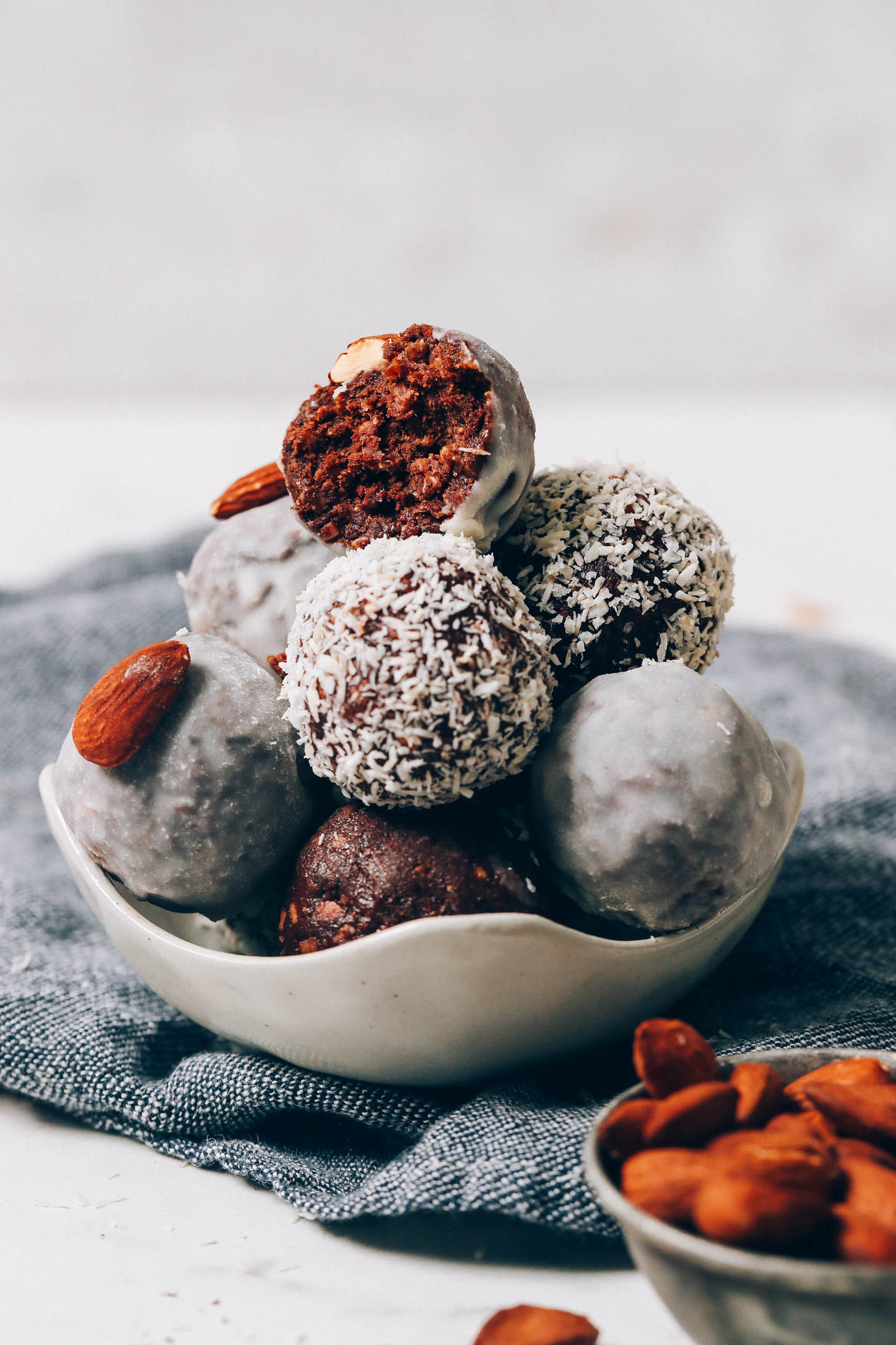 Bowl of Almond Joy Energy Bites with the top one half eaten to show texture
