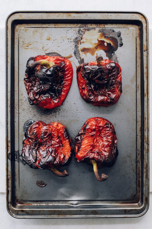 Baking sheet with four roasted red peppers