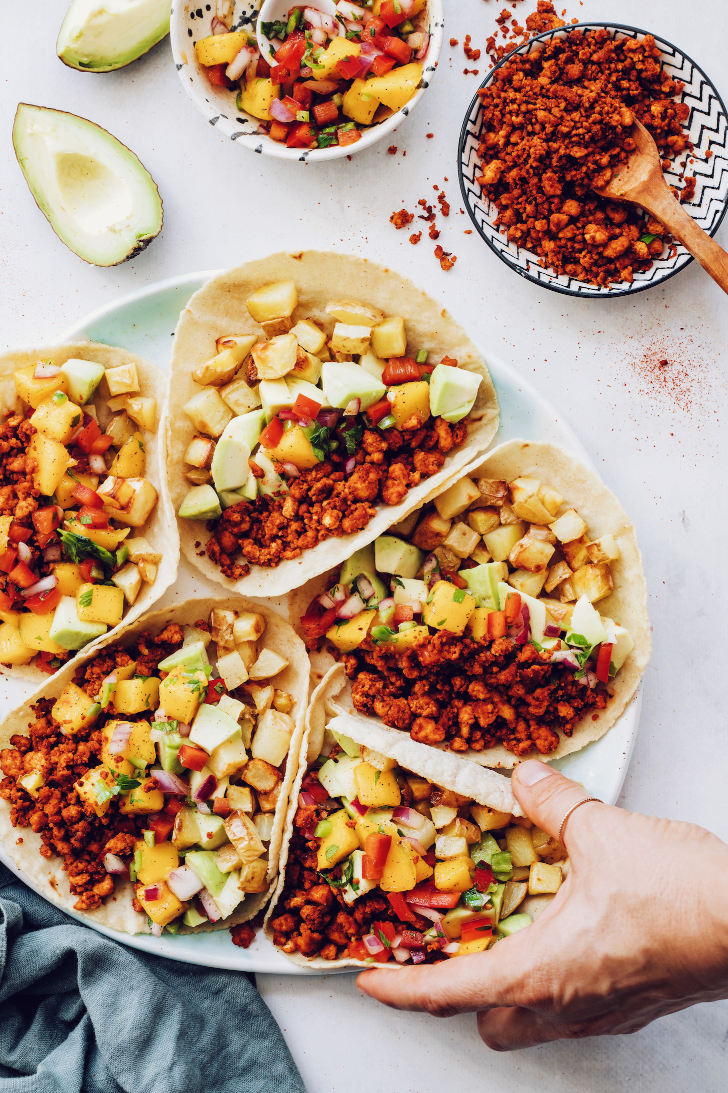 Picking up a breakfast taco from a platter with more tacos