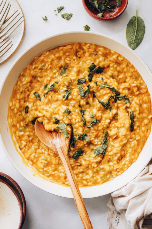 Pan of pumpkin risotto topped with crispy sage
