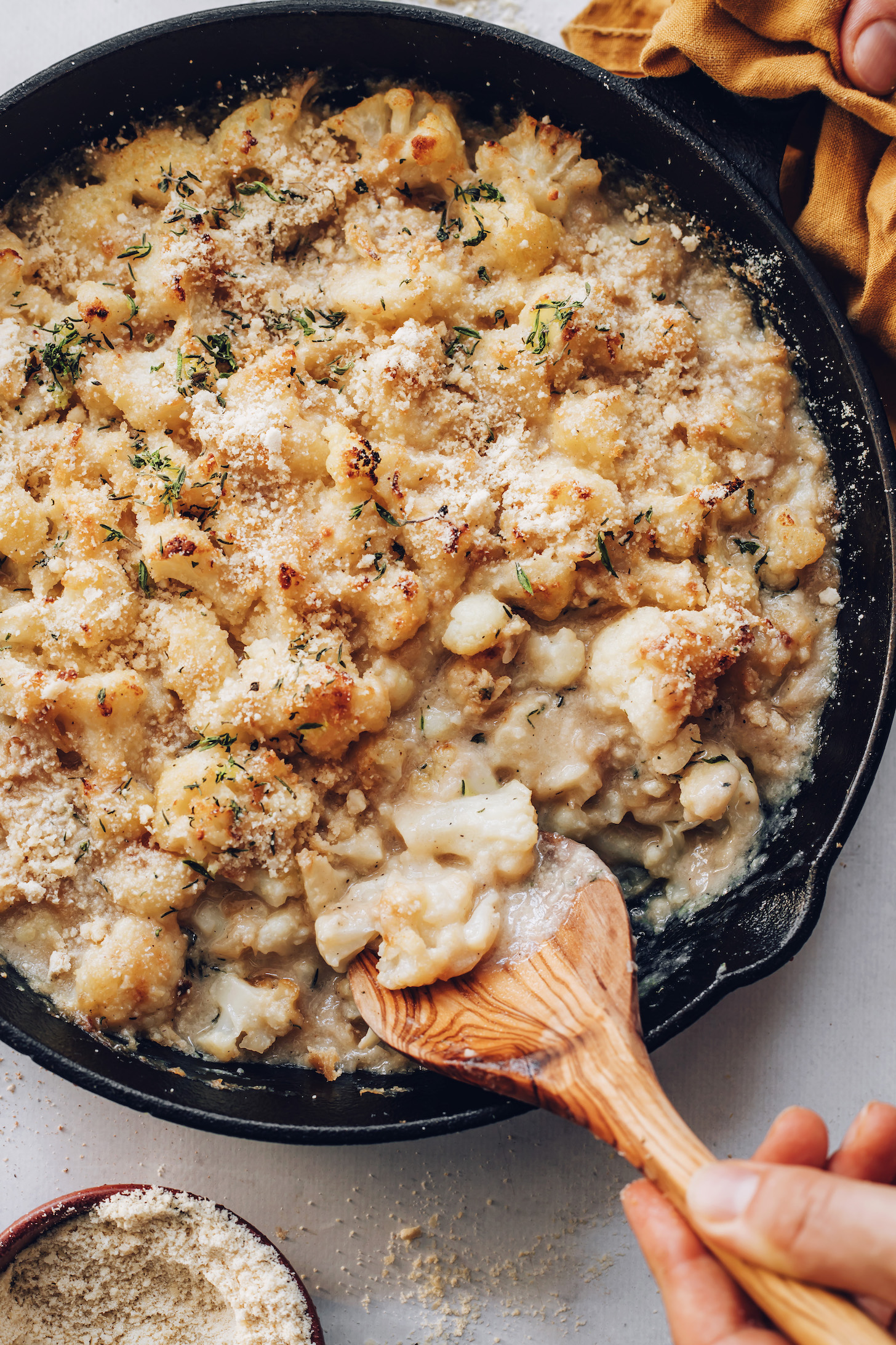Cast iron skillet of creamy cauliflower gratin