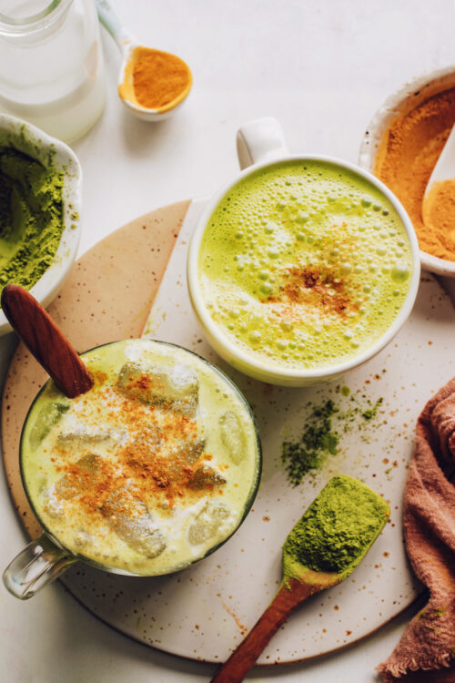 Mugs of iced and hot golden matcha lattes