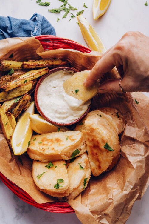 Dipping vegan fish into tartar sauce