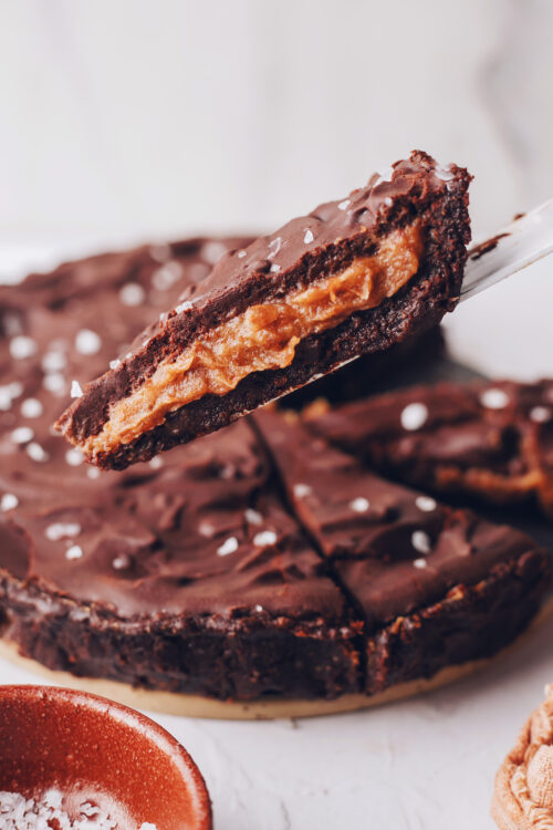Holding up a slice of our salted caramel chocolate ganache tart