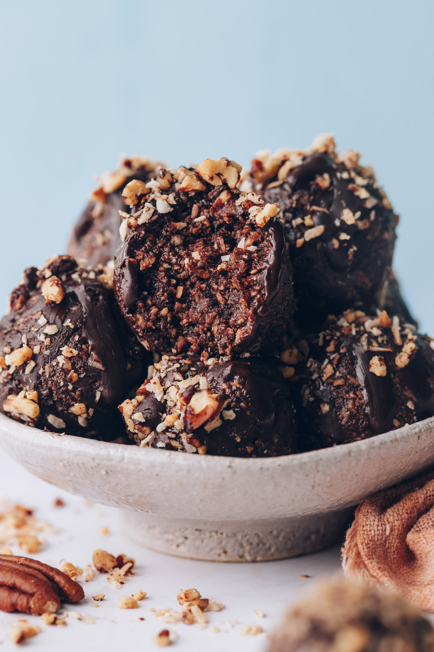 Showing the inner texture of a German chocolate cake energy bite with more bites in a bowl around them