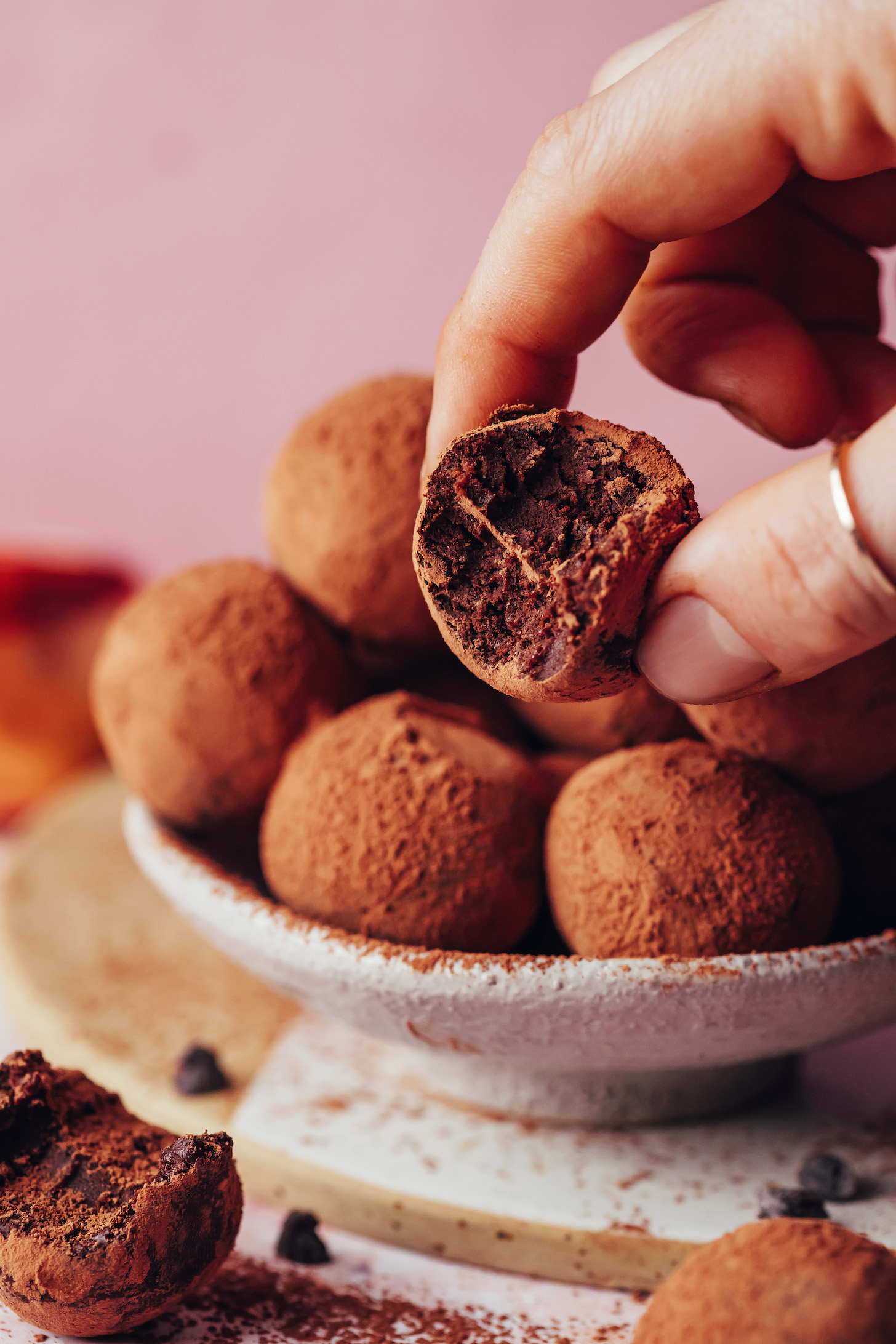 Fingers holding a fudgy dark chocolate sweet potato truffle