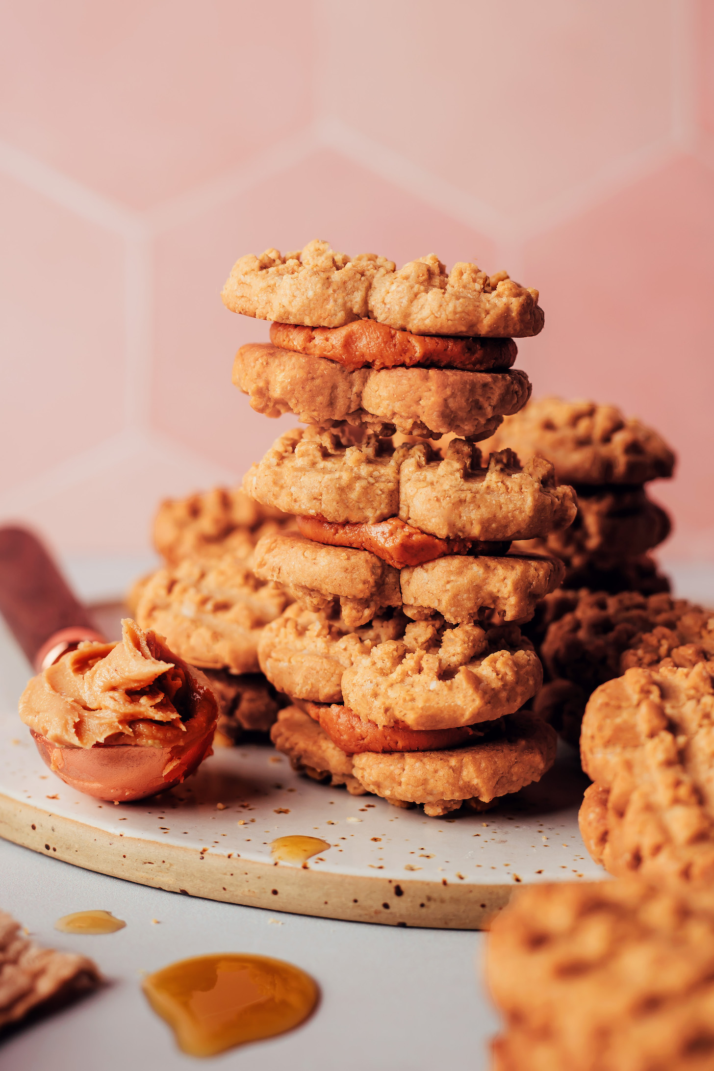 Spoonful of peanut butter next to a stack of vegan gluten-free Nutter Butters